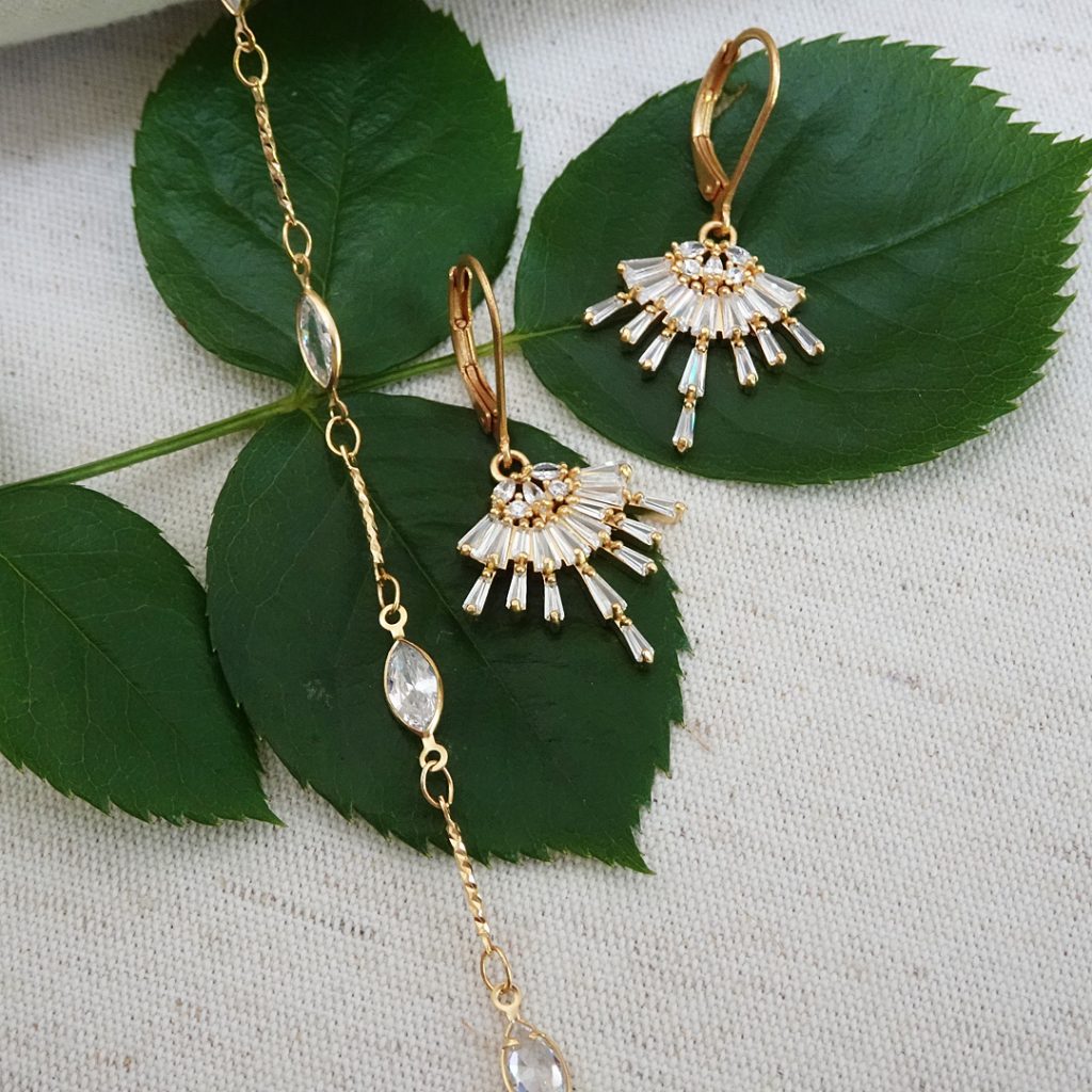 Delicate jewelry. Thin gold cable chain bracelet with marquis crystals spaced out, and a delicate cystal chandelier earring that compliments the bracelet