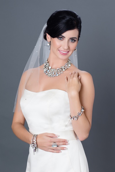 A sparkling veil from Sara Gabriel, joins Sorrelli white bridal statement necklace, bracelets, cuffs and a right hand ring.